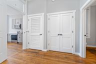 A kitchen with white cabinets and a wooden floor.