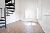 A room with a spiral staircase and wooden floors.
