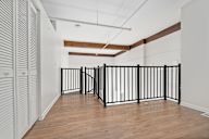 A room with a black gate and wooden floor.