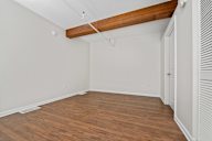 A room with wooden floors and a white wall.