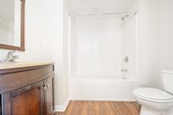 A white toilet sits next to a white bathtub in a bathroom.
