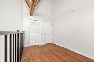 A room with a white door and a wooden floor.