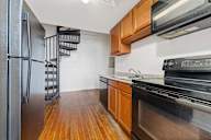 A kitchen with wooden floors and stainless steel appliances.