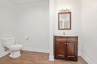 A white toilet sits next to a wooden cabinet with a mirror above it.