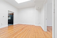 A room with wooden floors and a skylight.