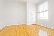 A room with wooden flooring and a white door.