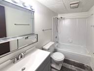 A white toilet sits next to a white sink in a bathroom.