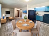 A modern kitchen with a dining table set for two.