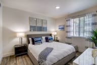Bright bedroom with a large bed and a window letting in natural light.