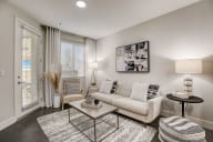Modern living room in Aria Apartments with sleek furniture and large windows