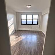 A room with a window and wooden flooring.