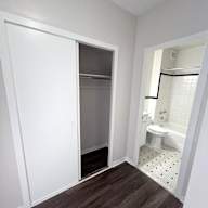 A white bathroom with a toilet and a walk in shower.