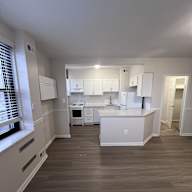 A kitchen with white appliances and cabinets.