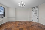 A room with a brown checkered floor and a white door.
