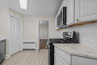 A kitchen with a stove top oven and a microwave above it.
