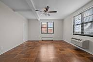 A room with a ceiling fan and a window with blinds.