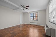 A room with a ceiling fan and a window with blinds.