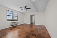 A room with a ceiling fan and a window with blinds.