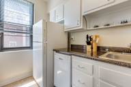 A kitchen with white appliances and white cabinets.