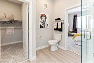 A bathroom with a white toilet and a white door.