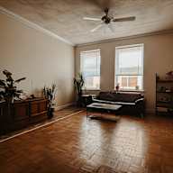 a living room with a couch coffee table and two windows