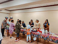 a group of people standing around a table with food on it