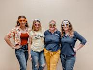 a group of women wearing sunglasses and smiling at the camera
