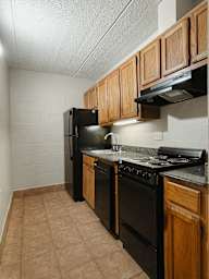 a kitchen with black appliances and wooden cabinets