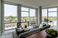 A living room with a couch, a chair, a table, and a bowl of fruit on the coffee table.
