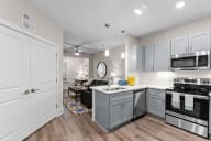 Active Adult kitchen and living room with white cabinets and stainless steel appliances