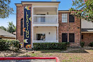 A brick building with a sign that says Leasing on it.