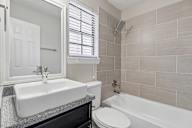 A bathroom with a white sink and a white toilet.