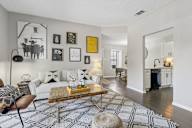 A living room with a white couch, a coffee table, and a rug with a geometric pattern.