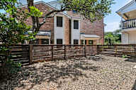 A house with a white fence and a tree in front.