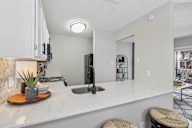 A kitchen with a marble countertop and a sink.