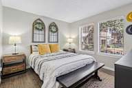 A bedroom with a bed, nightstand, and window.