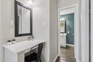 A bathroom with a white vanity and a mirror.