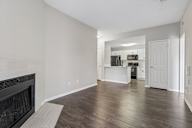 A large, empty living room with a fireplace and hardwood floors.