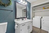 A bathroom with a white sink and a white toilet.