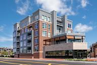 A modern multi-story building with a mix of brick and panel facade.