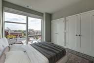 A bedroom with a large bed and a view of the city.