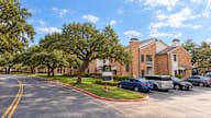 A sunny day at a residential area with cars parked on the side of the road.