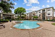 A swimming pool surrounded by apartment buildings.
