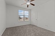 A room with a ceiling fan and a window with blinds.
