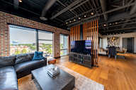 A living room with a black leather couch and a wooden coffee table.