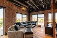 A living room with a black couch and a brown chair.