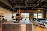 A modern kitchen with a large island and a view of the city.