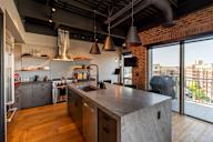 A modern kitchen with a large island and a view of the city.