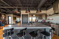 A modern kitchen with a large island and bar stools.
