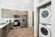 A modern kitchen with a washer and dryer in the laundry room.